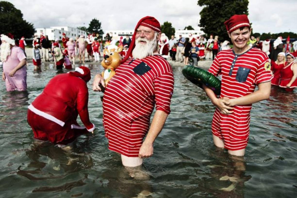 DINAMARCA. Bellevue se viste de fiesta. Personas vestidas de Papa Noel en el tradicional baño de pies del segundo día de la 59 edición del Congreso de Papás Noel.