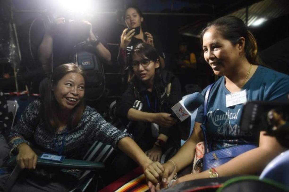 Family members celebrate while camping out near Than Luang cave following news all members of children's football team and their coach were alive in the cave at Khun Nam Nang Non Forest Park in the Mae Sai district of Chiang Rai province late July 2, 2018.<br/>Twelve boys and their football coach trapped in a flooded Thai cave for nine days were 'found safe' late July 2, in a miracle rescue after days of painstaking searching by divers. / AFP PHOTO / LILLIAN SUWANRUMPHA