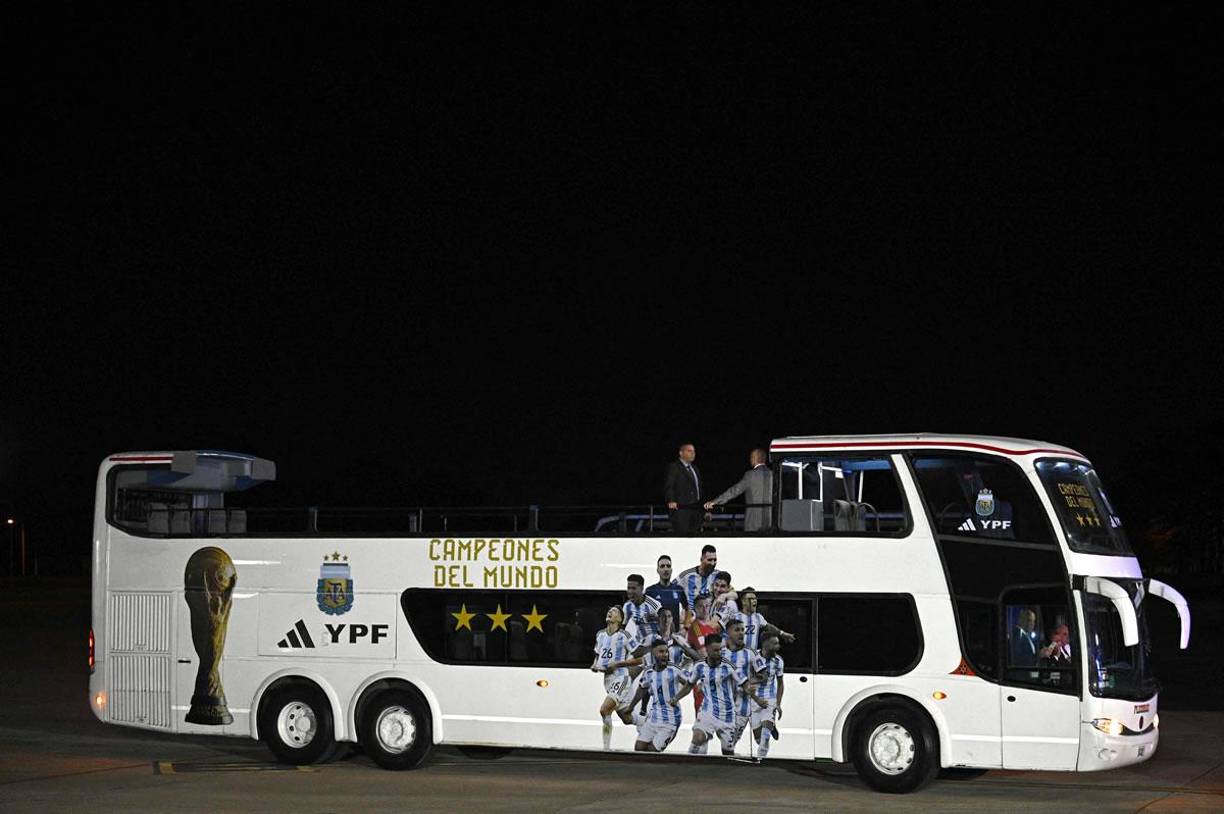 Este autobús descapotable de dos pisos con imágenes de los jugadores, las tres estrellas que desde ahora llevará la camiseta albiceleste y el rótulo “Campeones del mundo”, estaba esperando la llegada de los seleccionados para trasladarlos al lugar de concentración. 