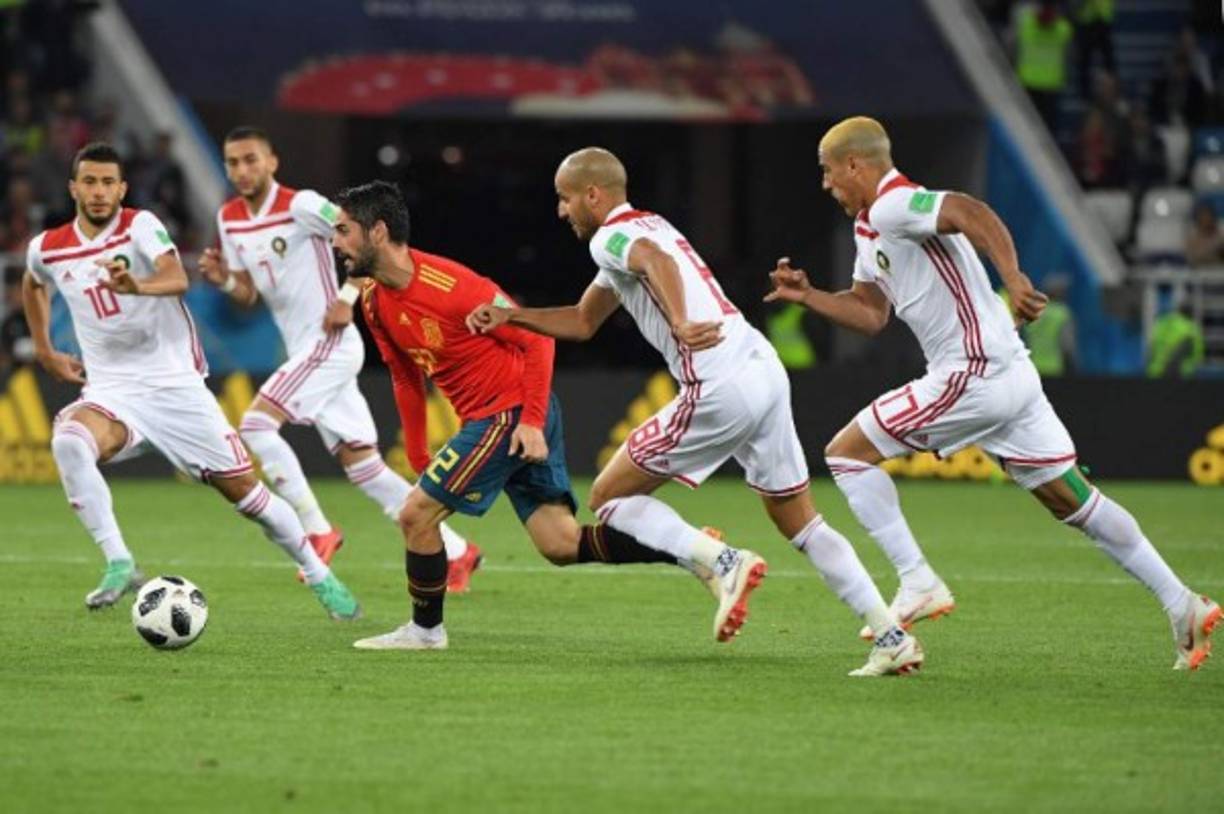 El mediocampista español Isco Alarcón es marcado por cuatro jugadores, una imagen que se retipe en el argentino Lionel Messi.