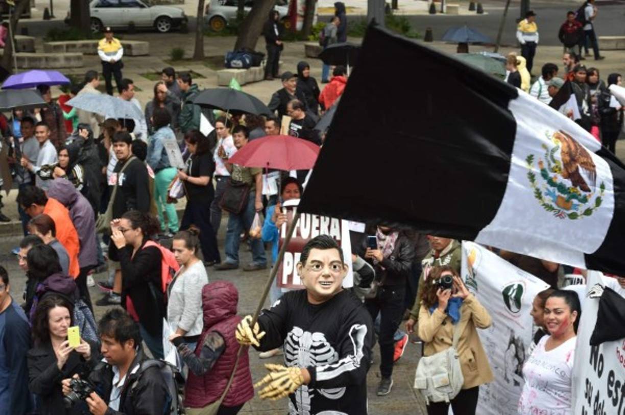 Cubriéndose como podían de la fuerte lluvia, los humildes padres de los estudiantes, amigos, vecinos y compañeros de clases encabezaron la marcha.