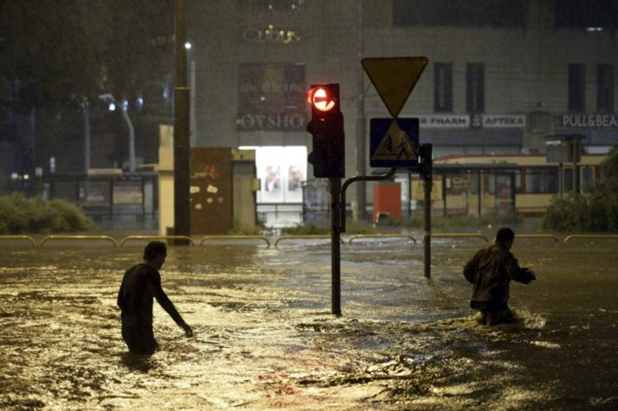 POLONIA. Caminata entre aguas. Dos personas caminan en una calle inundada en Gdansk . Las lluvias han causado serios daños en toda la ciudad. Foto: EFE/Adam Warzawa