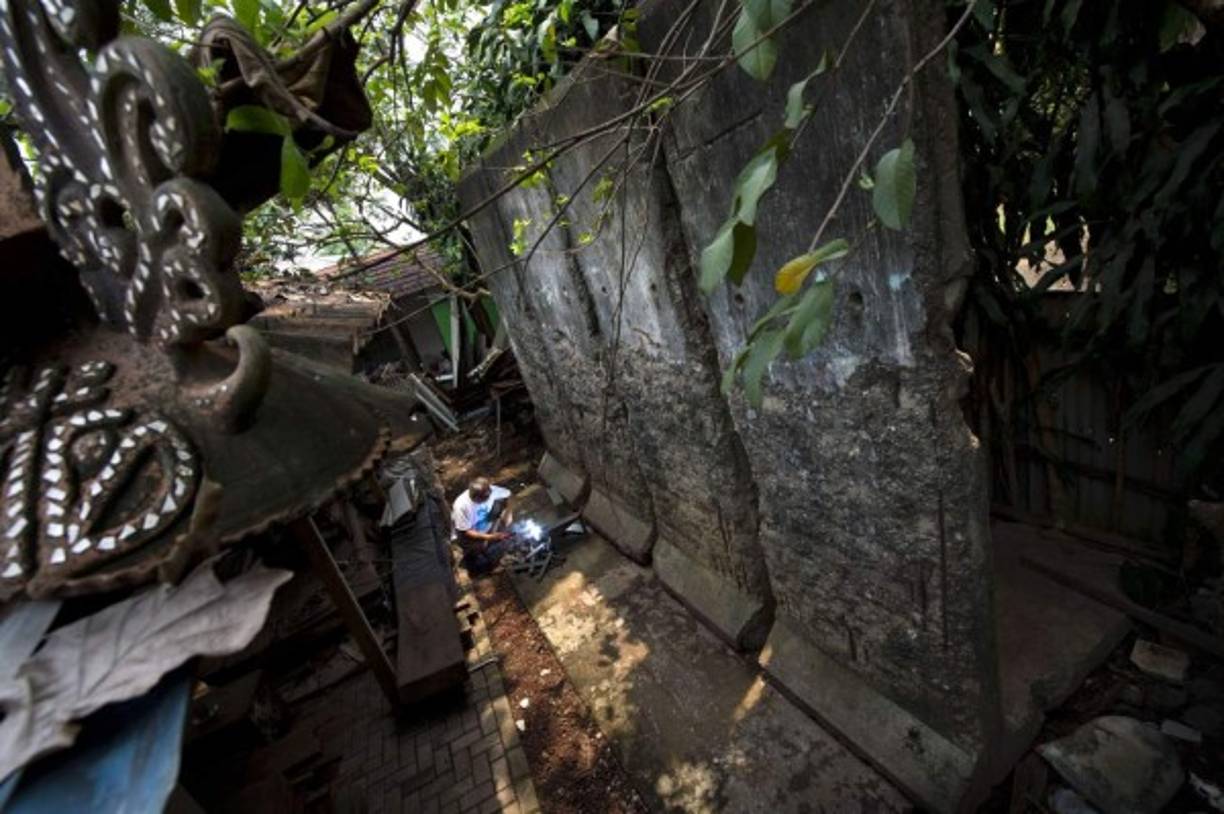 Un artista en Indonesia trabaja en secciones del muro de Berlín que mantiene en su taller de Jakarta. Los soviéticos sostenían que el muro fue levantado para proteger a su población de elementos fascistas que conspiraban para construir un estado socialista en Alemania del Este.