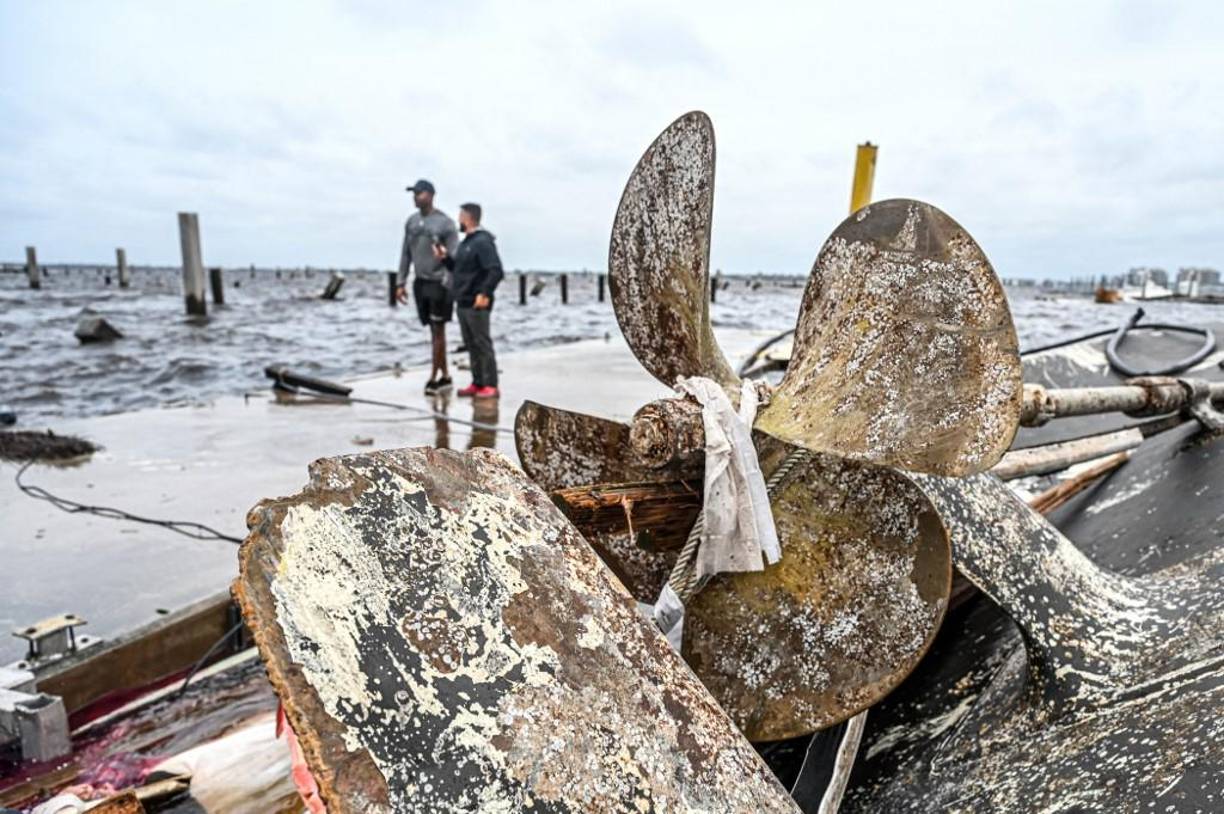 Los residentes inspeccionan los daños a un puerto deportivo mientras los barcos están parcialmente sumergidos después del huracán Ian en Fort Myers, Florida.