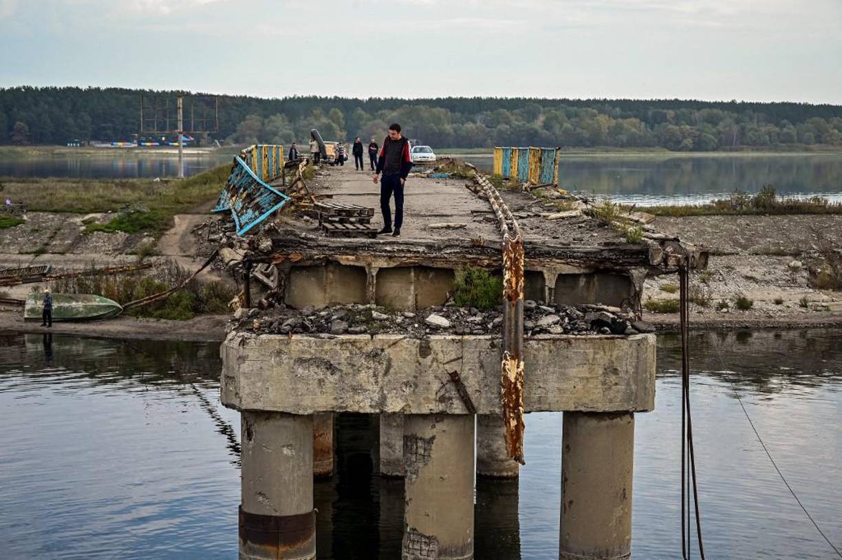 Un residente local camina sobre el puente destruido sobre el río Donets en Staryi Saltiv, al este de Kharkiv, el 30 de septiembre de 2022, en medio de la invasión rusa de Ucrania.