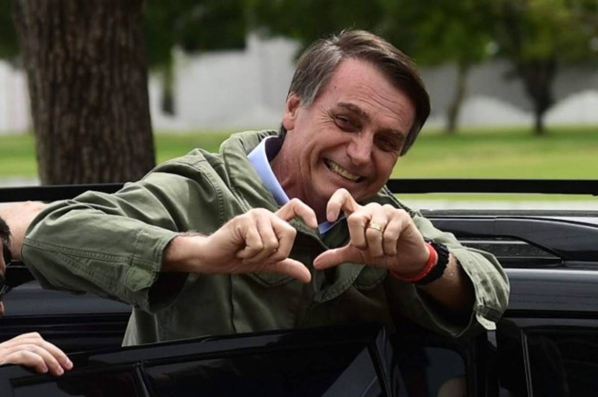 Jair Bolsonaro, far-right lawmaker and presidential candidate for the Social Liberal Party (PSL), gestures to supporters during the second round of the presidential elections, in Rio de Janeiro, Brazil on October 28, 2018. - Brazilians will choose their president today during the second round of the national elections between the far-right firebrand Jair Bolsonaro and leftist Fernando Haddad (Photo by MAURO PIMENTEL / AFP)