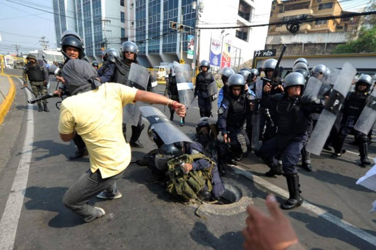 Indígenas lencas del Copinh se enfrentaron con policías antimotines frente a Casa Presidencial en Tegucigalpa. AFP