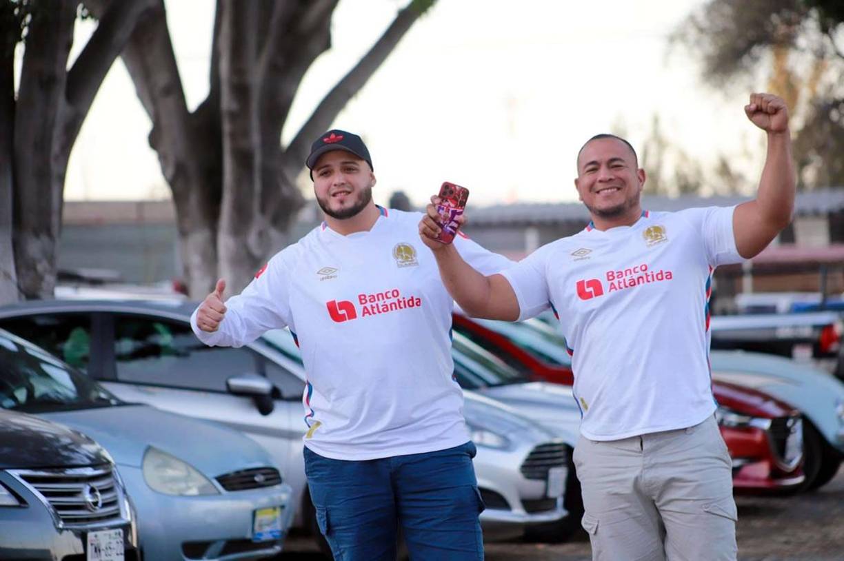 Estos dos hinchas merengues bien identificados con la camiseta del Olimpia.