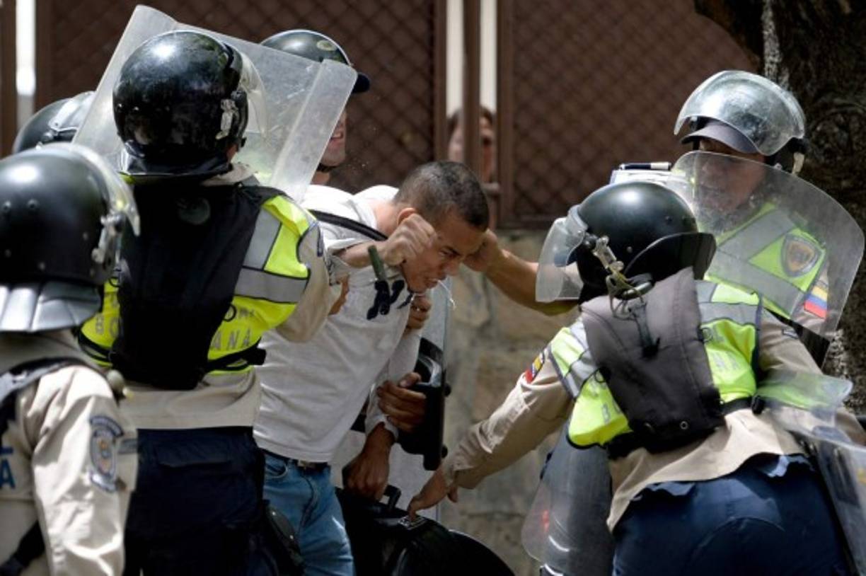 An opposition activist is arrested by riot police during a protest against President Nicolas Maduro's government in Caracas on April 4, 2017. <br/>Activists clashed with police in Venezuela Tuesday as the opposition mobilized against moves to tighten President Nicolas Maduro's grip on power. Protesters hurled stones at riot police who fired tear gas as they blocked the demonstrators from advancing through central Caracas, where pro-government activists were also planning to march. / AFP PHOTO / FEDERICO PARRA
