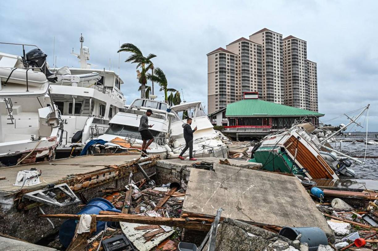 Los residentes inspeccionan los daños a un puerto deportivo mientras los barcos están parcialmente sumergidos después del huracán Ian en Fort Myers, Florida.