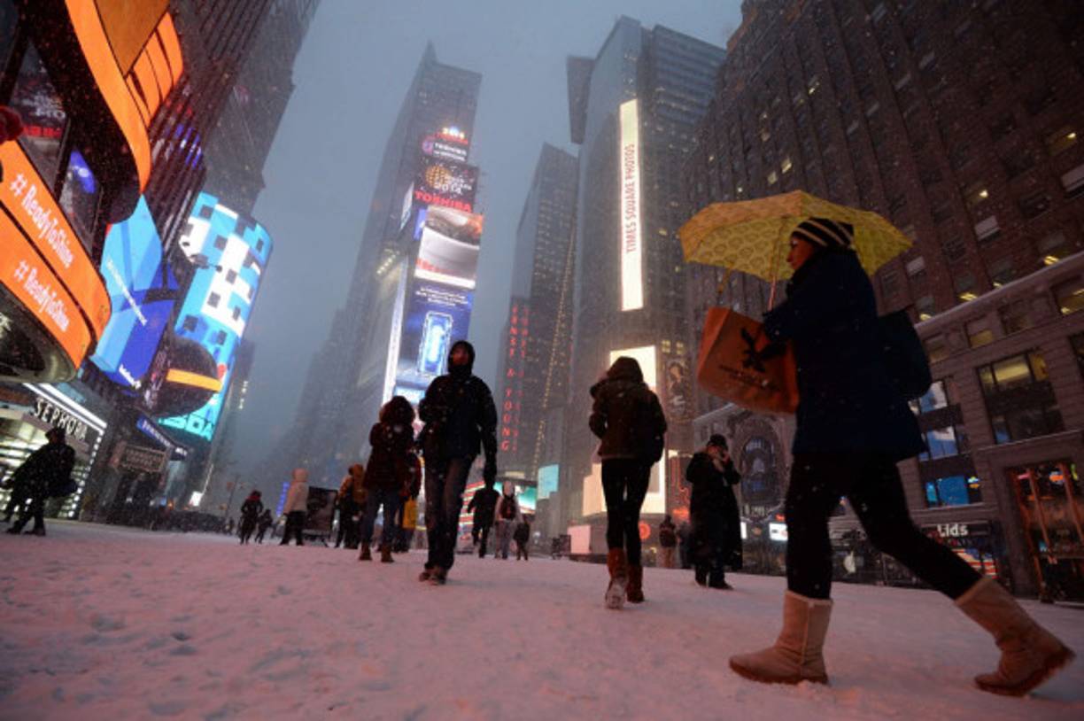 Neoyorquinos caminan por Times Square cubierto de nieve.