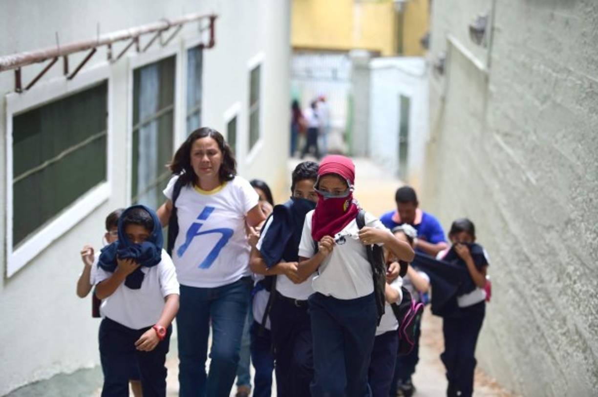 A paso veloz, los alumnos salían del Colegio San Pedro del sector Santa Mónica (oeste), tomados de la mano de sus representantes, que les cubrían los rostros con pañuelos.