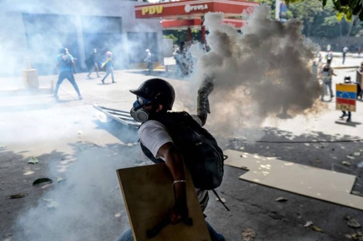 Opposition activists demonstrating against the government of Venezuelan President Nicolas Maduro clash with riot police in Caracas on June 26, 2017. <br/>A political and economic crisis in the oil-producing country has spawned often violent demonstrations by protesters demanding Maduro's resignation and new elections. The unrest has left 75 people dead since April 1. / AFP PHOTO / FEDERICO PARRA