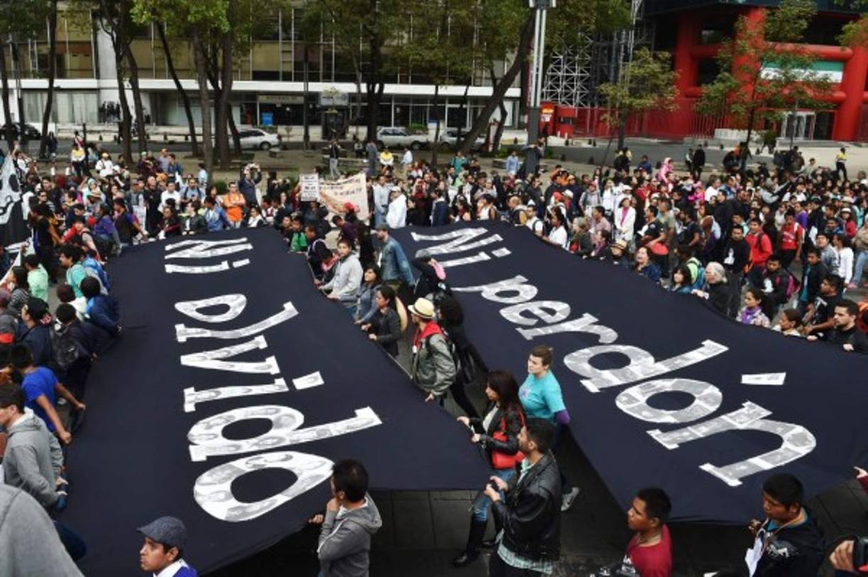 La 'Marcha de la Indignación Nacional' recorrió las principales calles, llevando grandes fotos de los jóvenes y gritando consignas en contra del gobierno de Enrique Peña Nieto y de su versión de este crimen, que exhibió la cara más oscura de México e indignó al mundo.