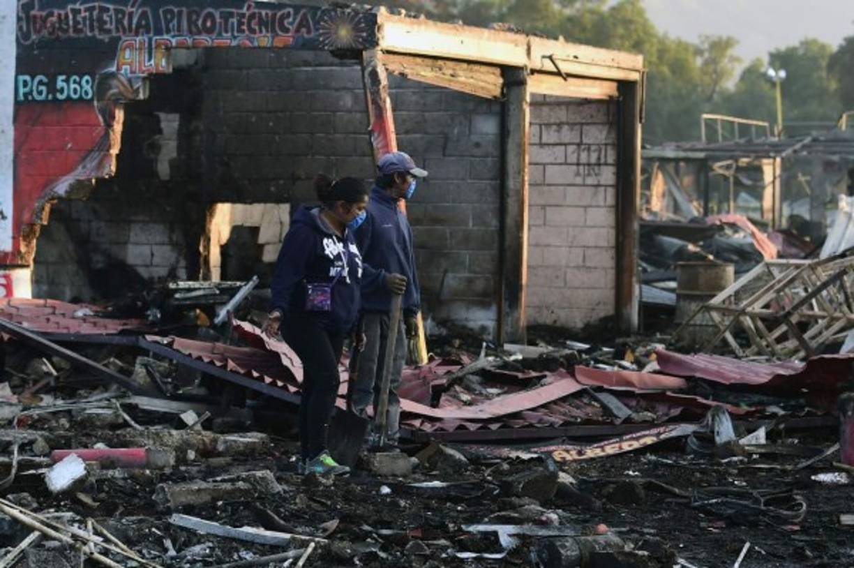 Los residentes buscan entre los escombros dejados por una enorme explosión que ocurrió en un mercado de fuegos artificiales. AFP