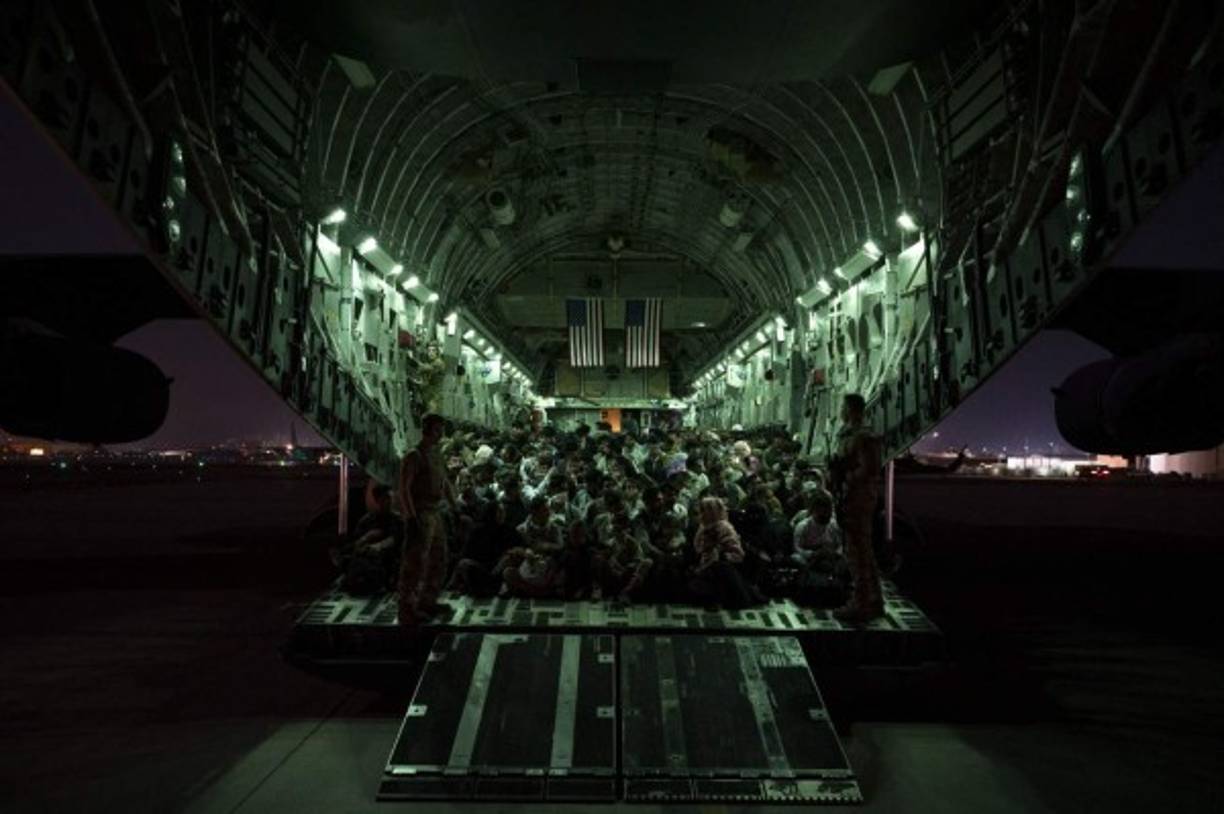 In this image courtesy of the US Air Force, a US Air Force aircrew, assigned to the 816th Expeditionary Airlift Squadron, assists qualified evacuees aboard a US Air Force C-17 Globemaster III aircraft in support of the Afghanistan evacuation at Hamid Karzai International Airport, Kabul, Afghanistan, August 21, 2021. - President Joe Biden on Sunday said he still hopes to complete the 'heartbreaking' evacuation from Afghanistan by the end of the month but warned of potential terrorist attacks against the crowded Kabul airport. (Photo by Taylor Crul / US AIR FORCE / AFP) / RESTRICTED TO EDITORIAL USE - MANDATORY CREDIT 'AFP PHOTO / Taylor Crul / US Air Force ' - NO MARKETING - NO ADVERTISING CAMPAIGNS - DISTRIBUTED AS A SERVICE TO CLIENTS