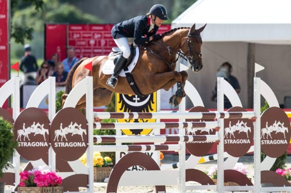ECUESTRE. Galope y brinco. La británica Kristina Cook junto con su caballo Billy the Red pasan del obstáculo de saltos por el Campeonato de Europa en Strzegom, Polonia.