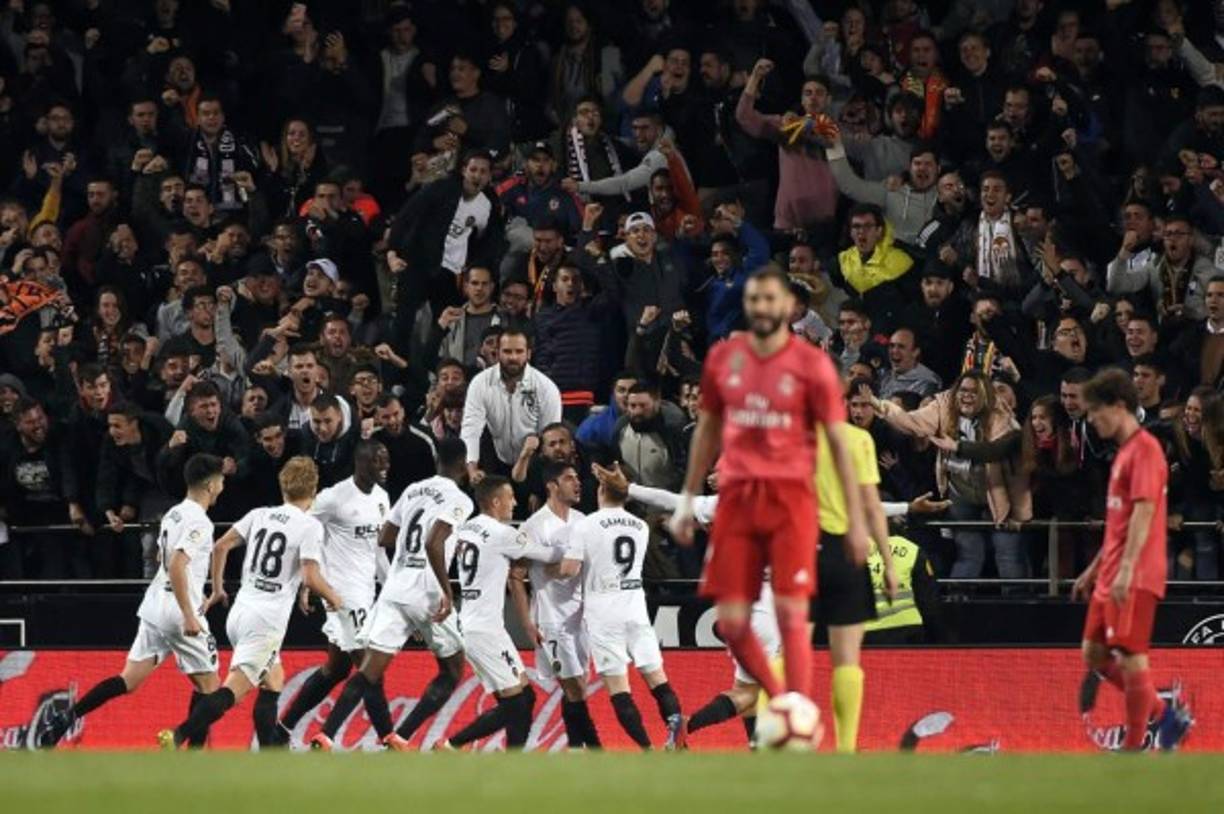 Los jugadores del Valencia celebrando el gol de Guedes, mientras Benzema camina a sacar del medio campo. Foto AFP