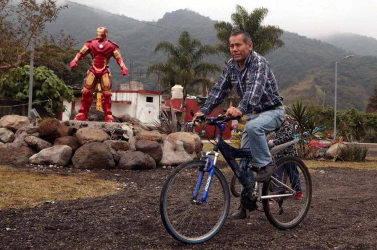 Un ciclista circula cerca de donde se yergue la figura de Iron Man