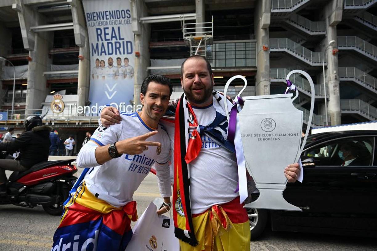 Two Real Madrid fans pose outside the stadium ahead of the UEFA Champions League semi-final second leg football match between Real Madrid CF and Manchester City at the Santiago Bernabeu stadium in Madrid on May 4, 2022. (Photo by Paul ELLIS / AFP)