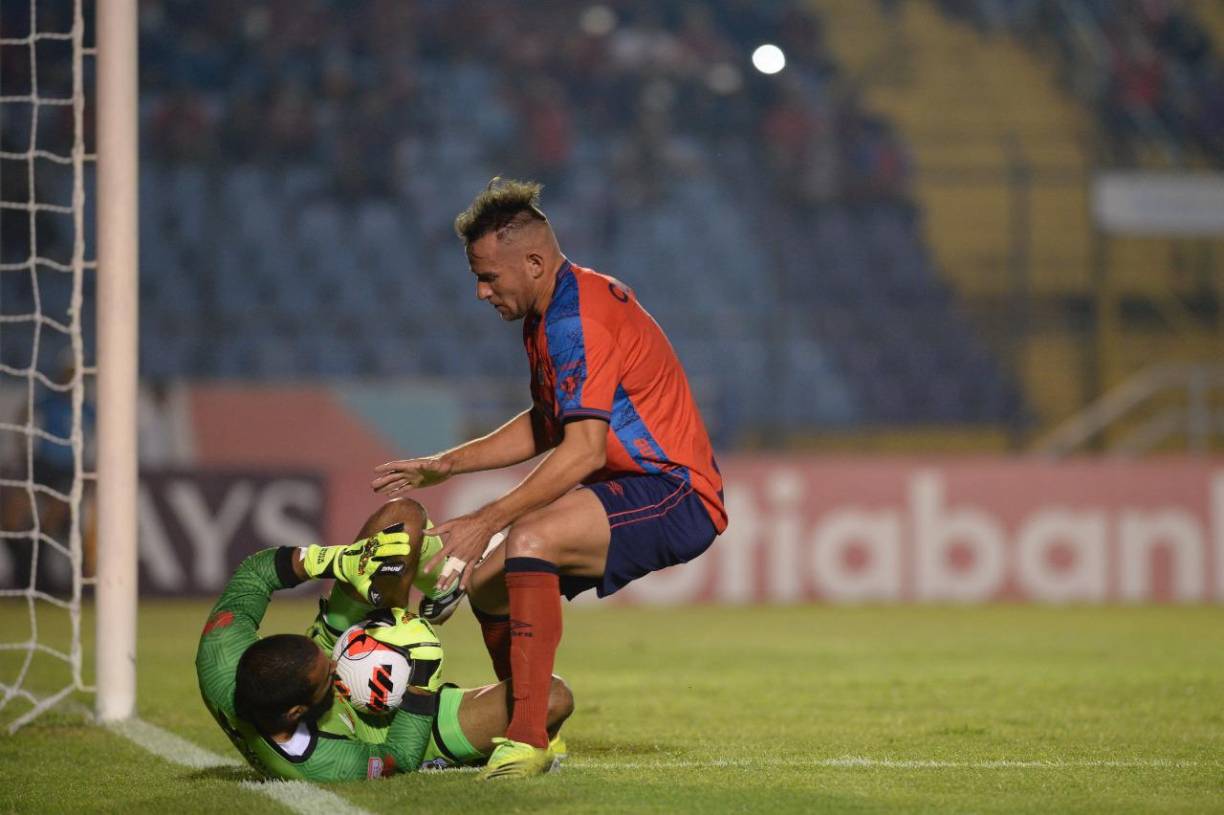 Edrick Menjívar se queda con el balón ante la presión de un jugador del Municipal.