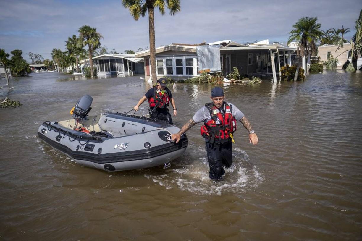 El personal de búsqueda y rescate vadea las aguas de un vecindario inundado mientras busca sobrevivientes después del huracán Ian, en Fort Myers, Florida.