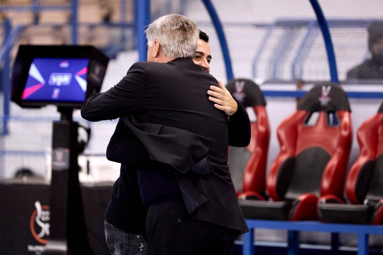 Carlo Ancelotti y Xavi Hernández se saludan antes del inicio del partido.
