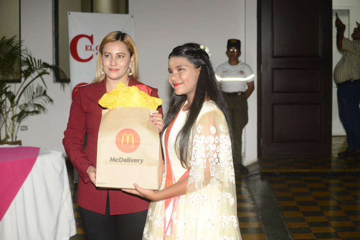 Esther Gómez, de la Gerencia de Competitividad de la Municipalidad de San Pedro Sula, entrega un premio a María José Tejada, ganadora del tercer lugar. 