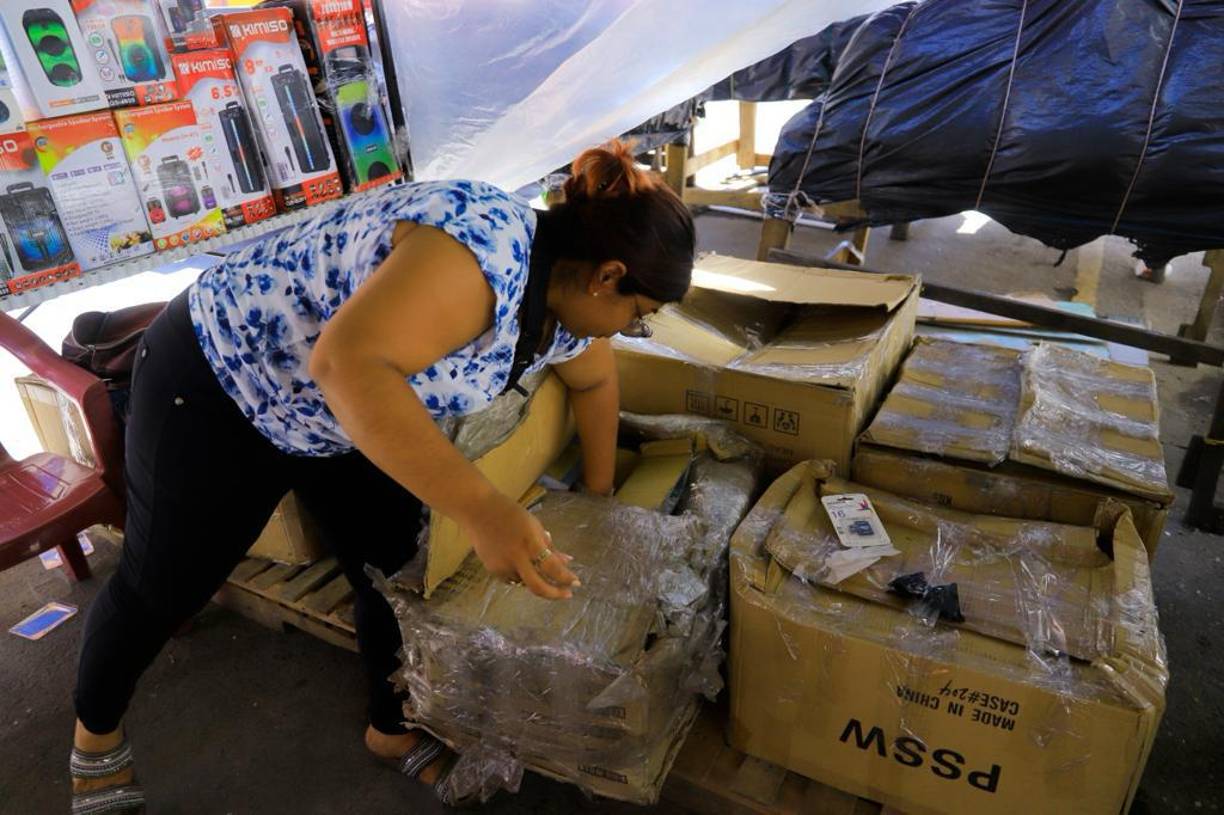 Sacando la mercadería de las cajas nos encontramos a esta vendedora que entre los productos ofrece tarjetas de almacenamiento para celular.