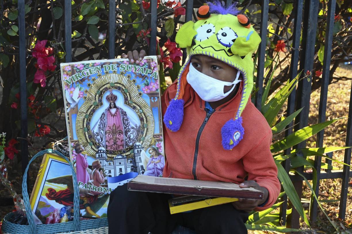  Un niño sostiene un cartel que representa a la Virgen de Suyapa, patrona de Honduras, afuera de la Basílica de Suyapa en el 275 aniversario de su aparición, en Tegucigalpa, el 3 de febrero de 2022.