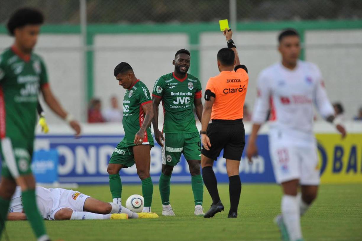 El árbitro Armando Castro le muestra tarjeta amarilla a Clayvin Zúniga por una falta sobre Jonathan Paz.