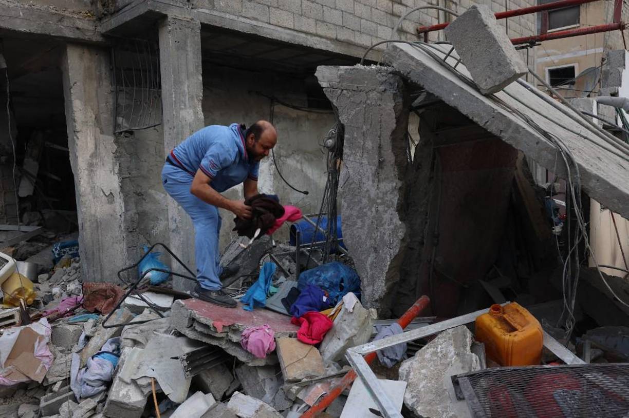  Un palestino busca artículos recuperables entre los escombros de un edificio arrasado tras los ataques aéreos israelíes nocturnos contra Rafah, en el sur de la Franja de Gaza.