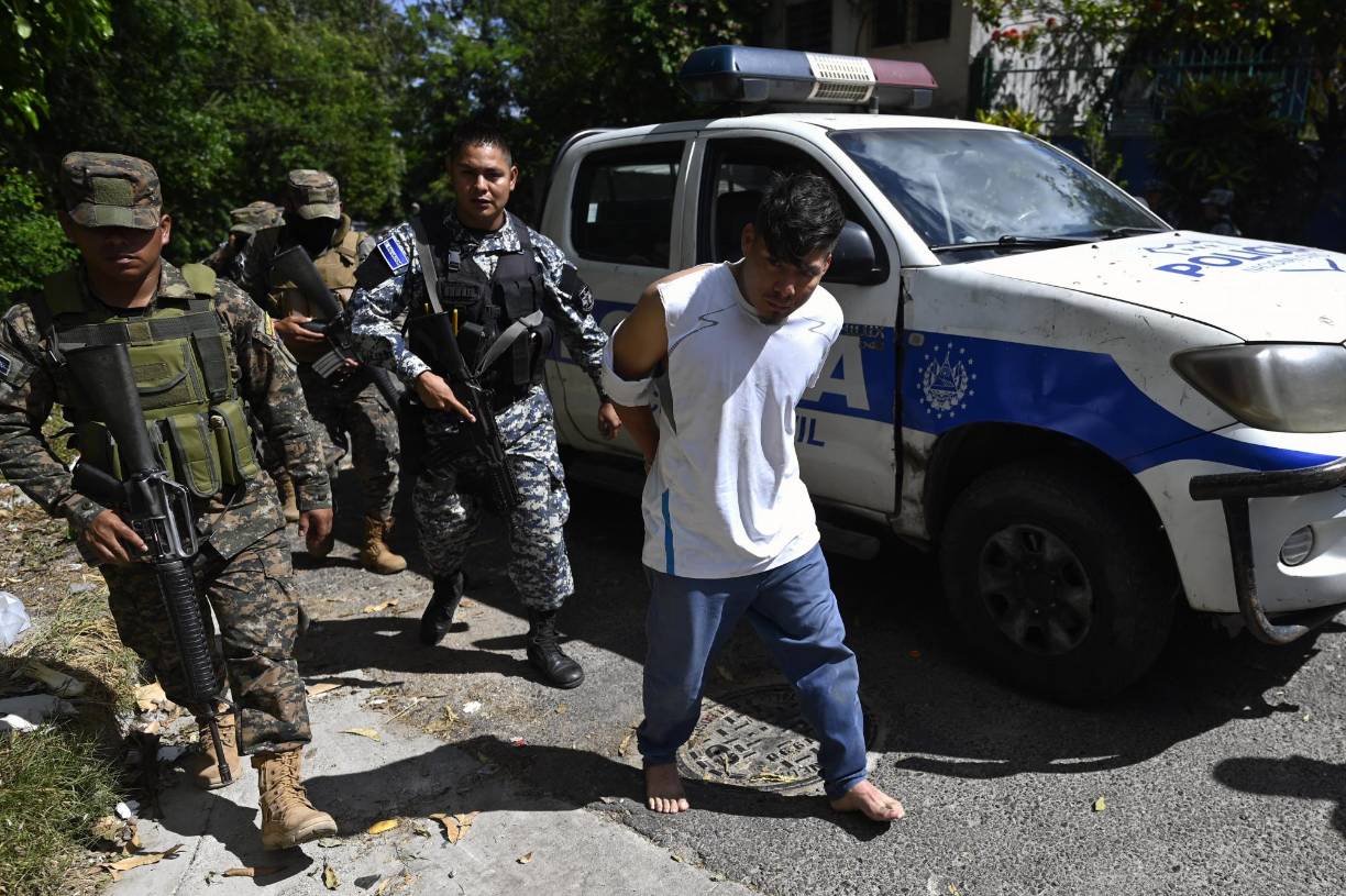 Police and soldiers escort people captured during an operation against gang members in Soyapango, El Salvador, on December 3, 2022. - Around 10,000 Salvadoran army troops and police officers surrounded the populous city of Soyapango, on the outskirts of capital San Salvador, as the government stepped up its fight against criminal gangs, President Nayib Bukele announced Saturday. (Photo by Marvin RECINOS / AFP)