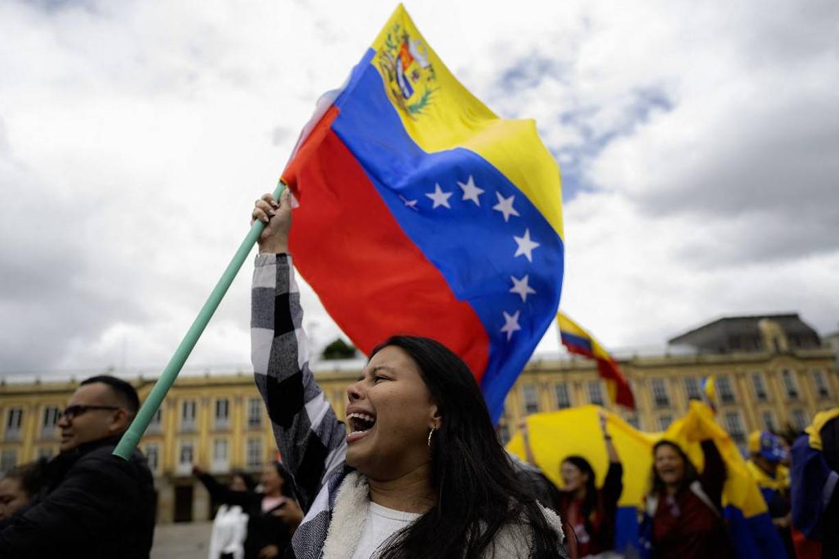 A demonstrator waves a Venezuelan flag while shouting slogans during a protest against Venezuelan President Nicolas Maduro's disputed victory in the presidential elections on July 28 at Bolivar Square in Bogota on August 3, 2024. (Photo by Luis ACOSTA / AFP)