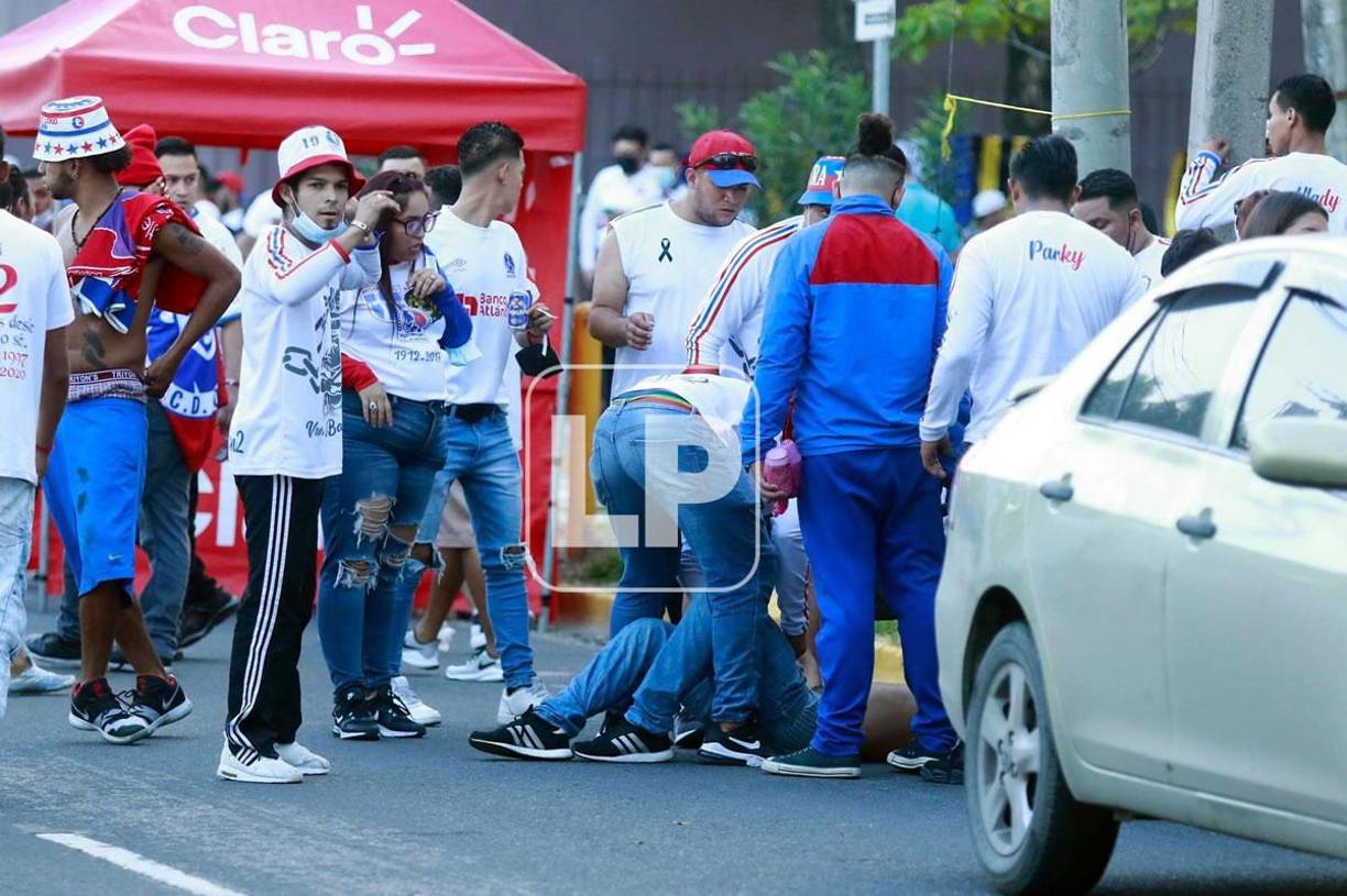 Otro aficionado del Olimpia tirado en el suelo de la primera calle tras resultar herido.