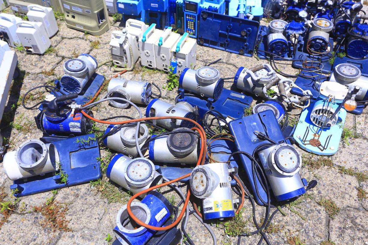 Máquinas médicas para diversos usos que dejaron de funcionar se deterioran bajo el sol.