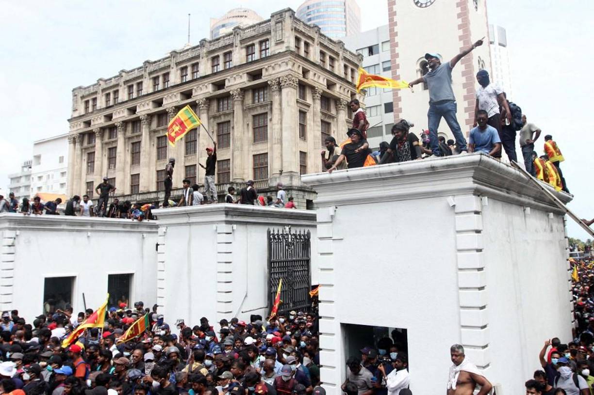 Protestors demanding the resignation of Sri Lanka's President Gotabaya Rajapaksa gather inside the compound of Sri Lanka's Presidential Palace in Colombo on July 9, 2022. - Sri Lanka's beleaguered President Gotabaya Rajapaksa fled his official residence in Colombo, a top defence source told AFP, before protesters gathered to demand his resignation stormed the compound. (Photo by AFP)
