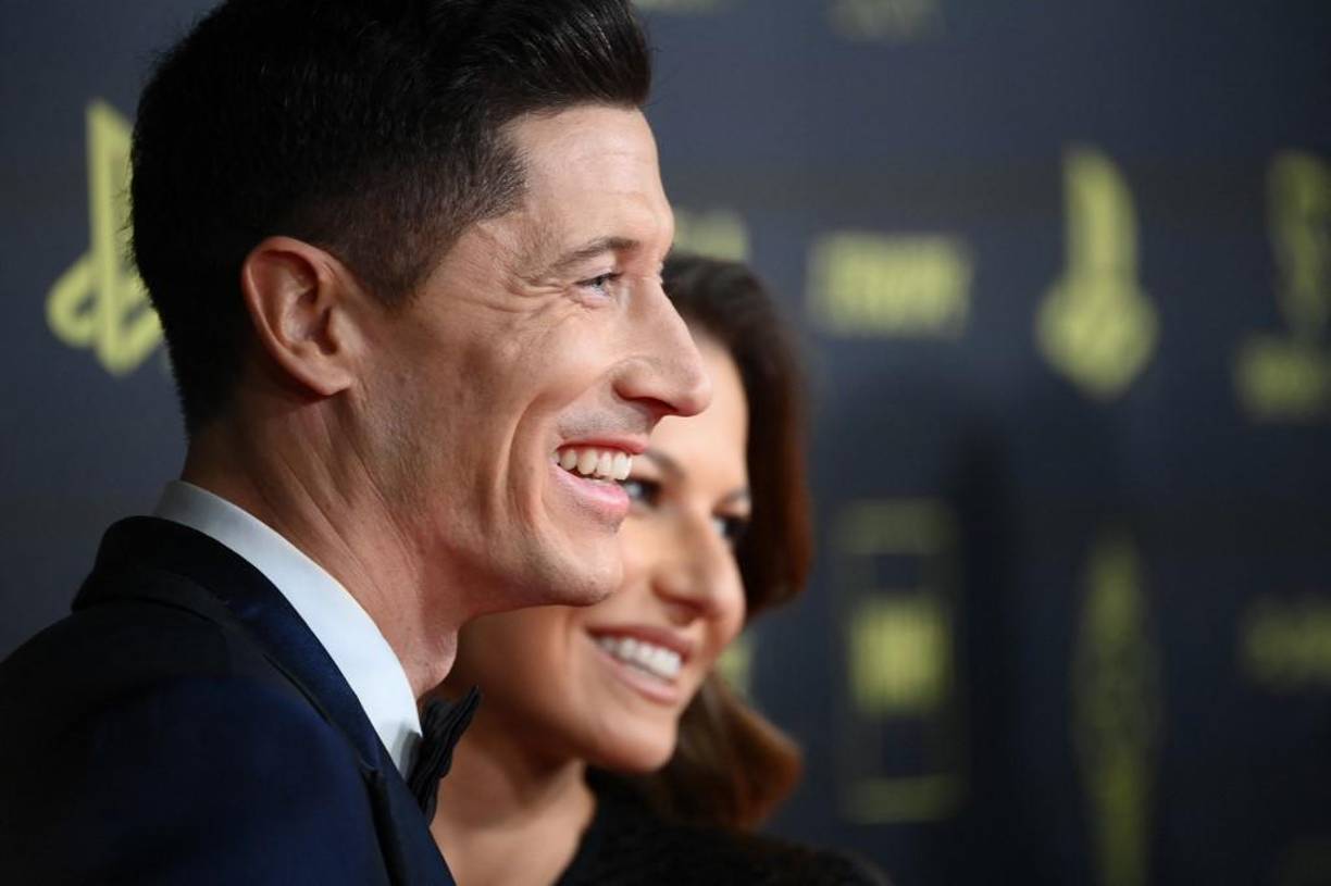 Robert Lewandowski sonriendo al lado de su bella esposa.