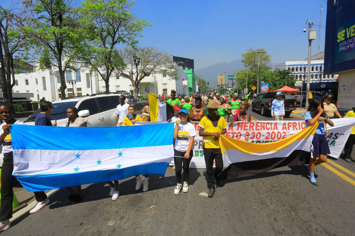 Al ritmo de tambores y vistiendo coloridos trajes con estampados, miembros de la comunidad garífuna marcharon desde la Plaza de las Banderas hasta el parque central.