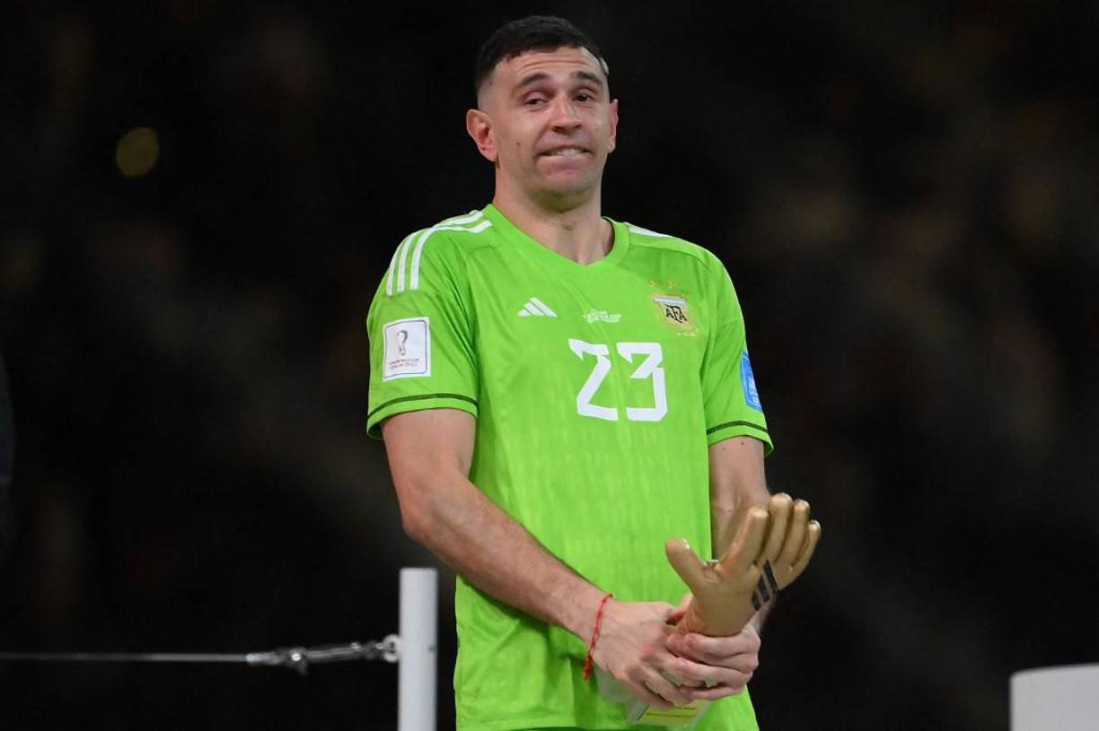 Argentina's goalkeeper #23 Emiliano Martinez displays the Golden Glove award during the Qatar 2022 World Cup trophy ceremony after the football final match between Argentina and France at Lusail Stadium in Lusail, north of Doha on December 18, 2022. - Argentina won in the penalty shoot-out. (Photo by FRANCK FIFE / AFP)