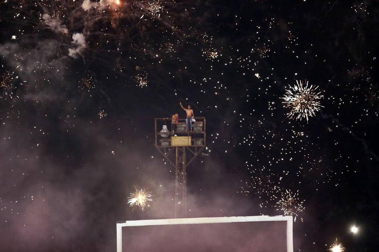 El riesgo que tomaron aficionados para poder ver al Olimpia. Desde una de las torres de luz miraron el partido.