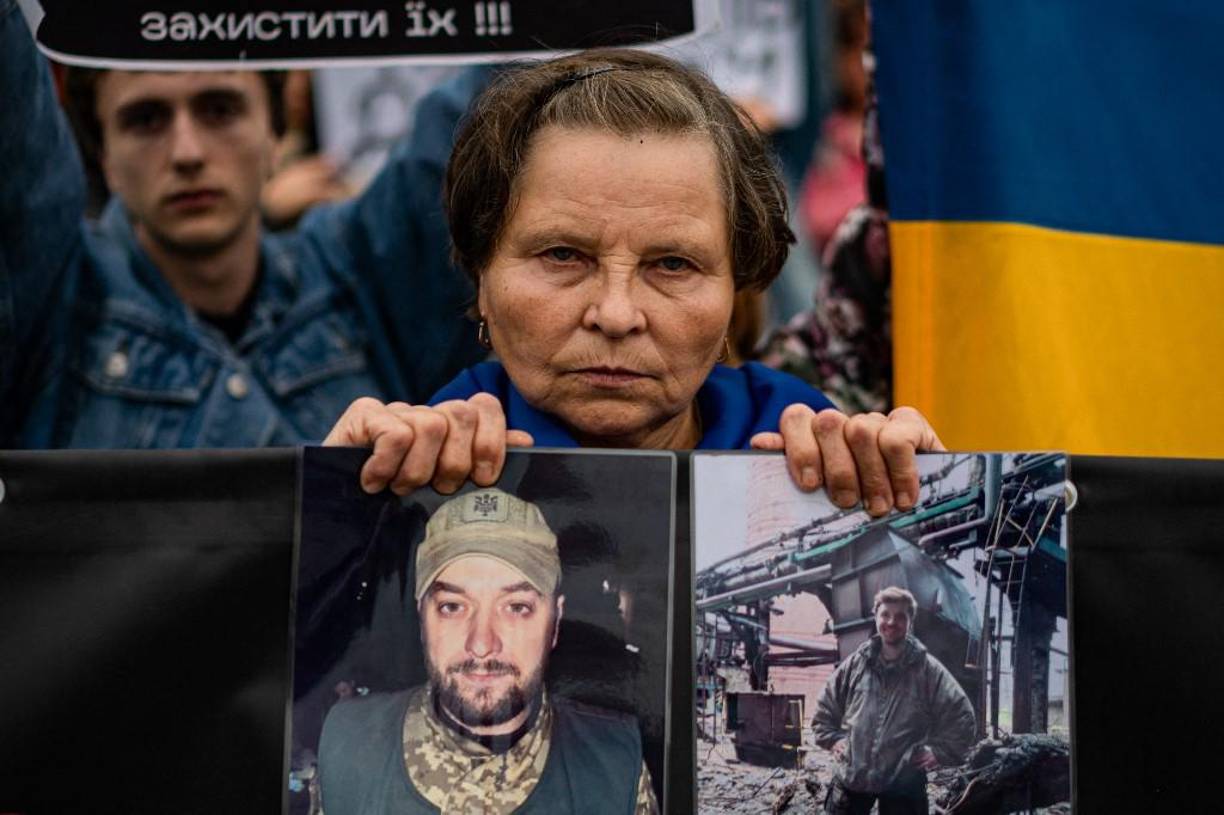 Una mujer sostiene fotografías de su hijo durante una manifestación que exige acelerar la liberación de la autoridad rusa de los prisioneros ucranianos involucrados en la batalla de la planta siderúrgica Azovstal en Mariupol, en el centro de Kiev, en medio de la invasión militar rusa de Ucrania.