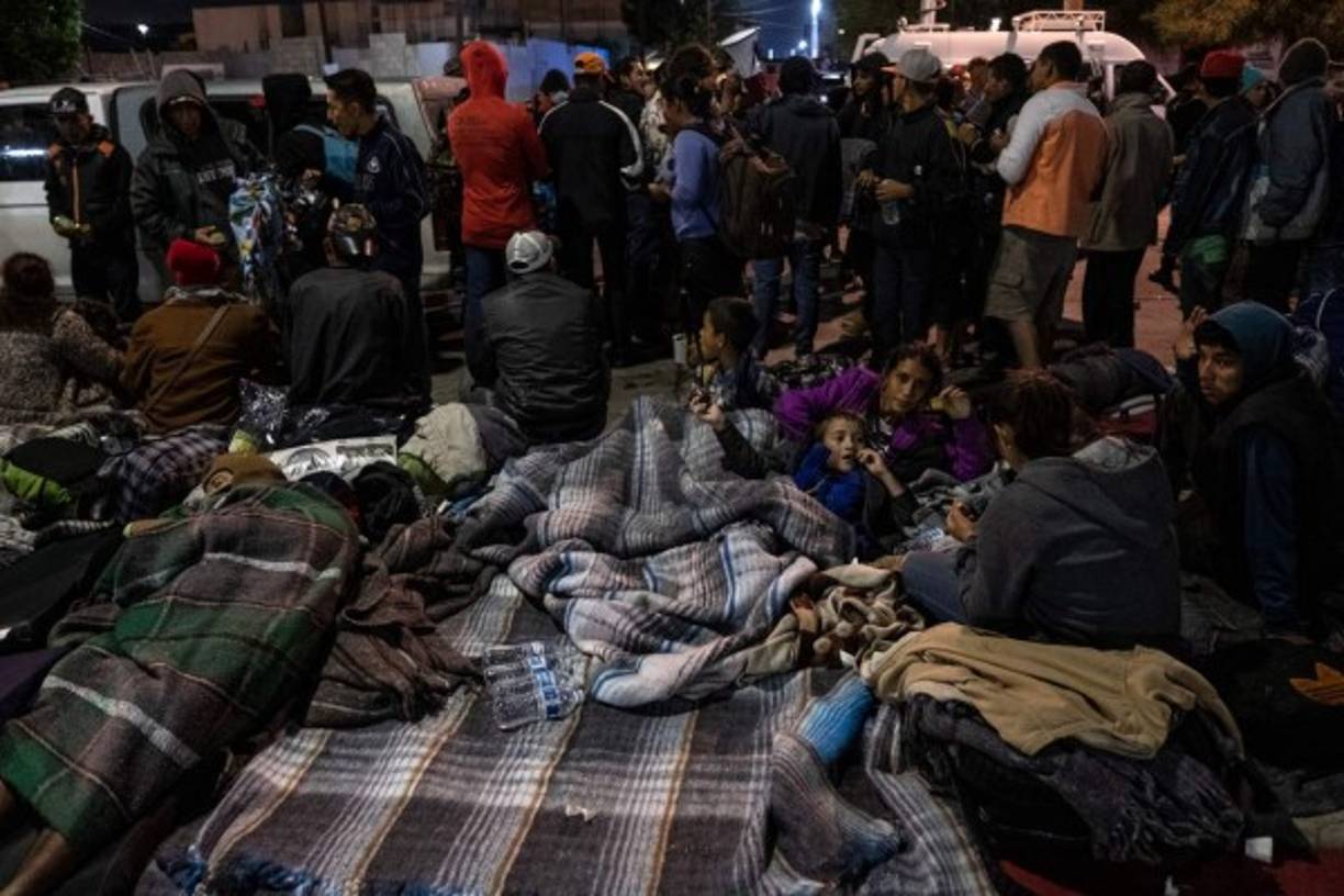 A group of Central American migrants - mostly from Honduras - moving towards the United States, rest near el Chaparral port of entry at the US-Mexico border after a demonstration as Federal Police guards in Tijuana, Baja California state, Mexico, on November 22, 2018. - US President Donald Trump renewed his attacks on the judiciary on Thanksgiving Day Thursday, accusing judges of making the country unsafe as he fanned a bitter row over asylum seekers on the US-Mexico border. (Photo by Guillermo Arias / AFP)