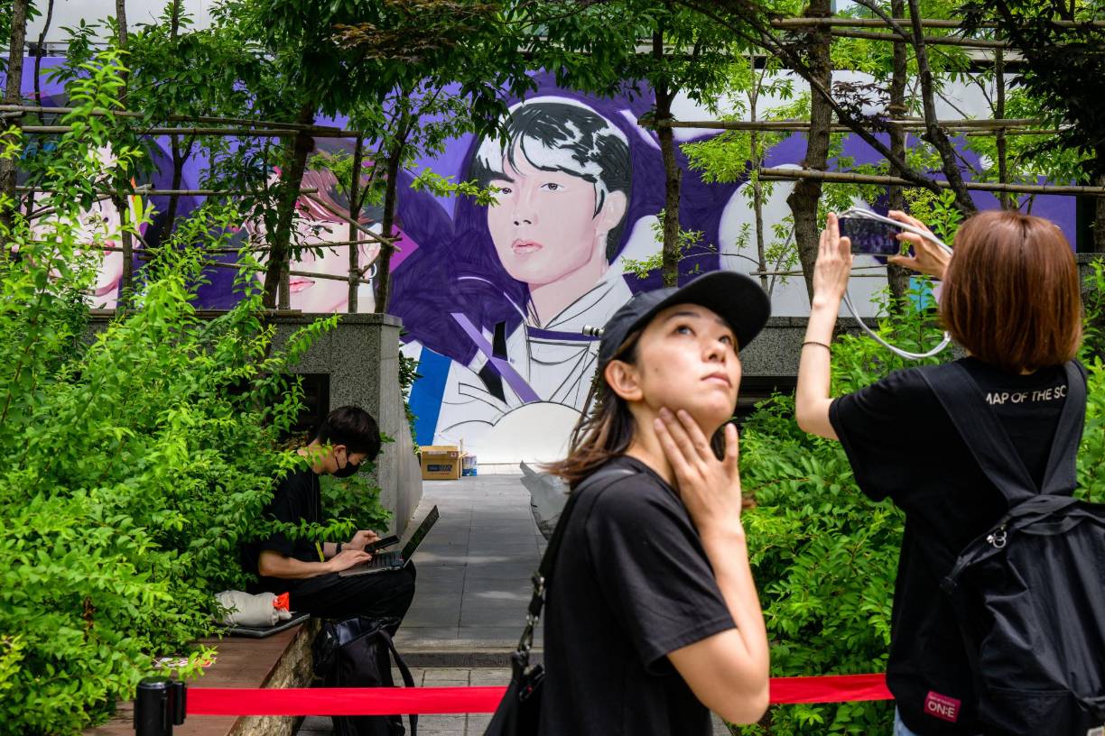 Fans del grupo - que se hacen llamar ARMY - se dieron cita por la mañana frente a las oficinas de su agencia HYBE, cuya fachada exhibe un enorme mural de la banda, para hacerse selfies o grabar videos en TikTok del acontecimiento.