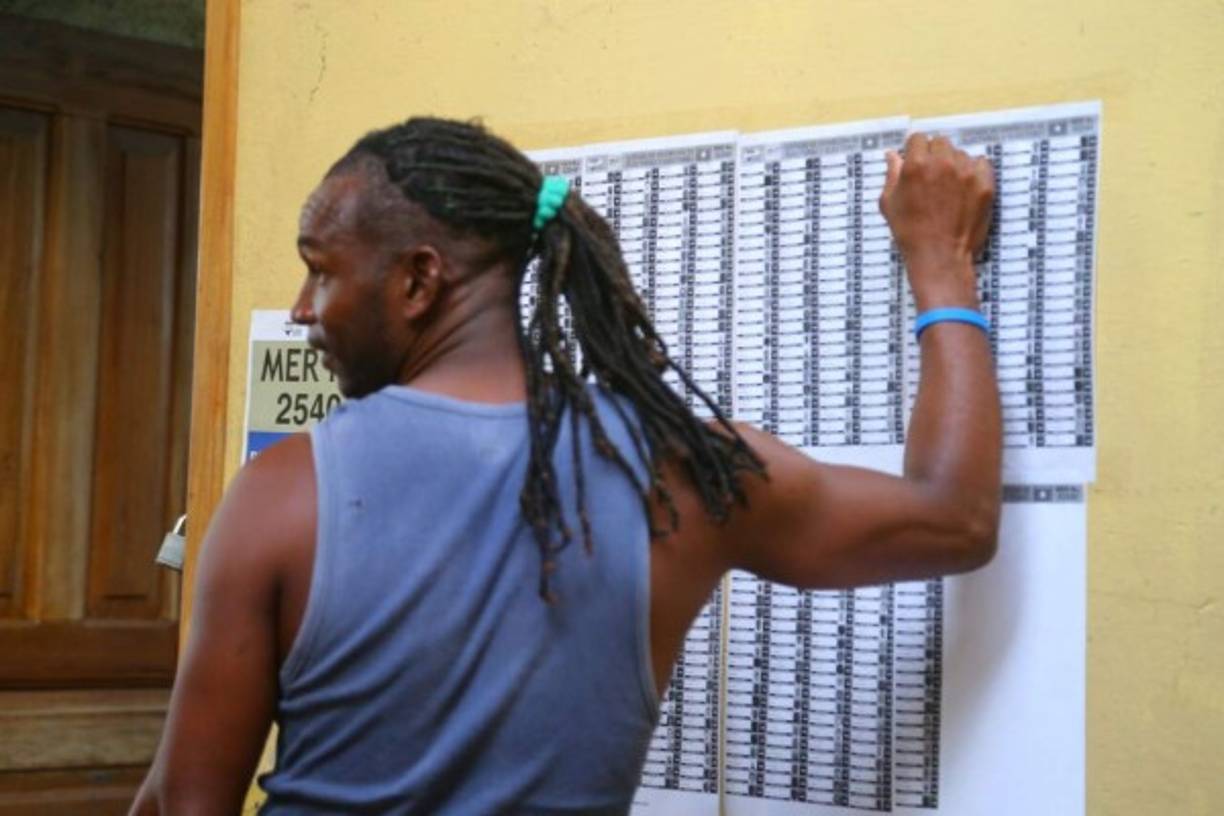 Un hombre mira dónde le toca votar.