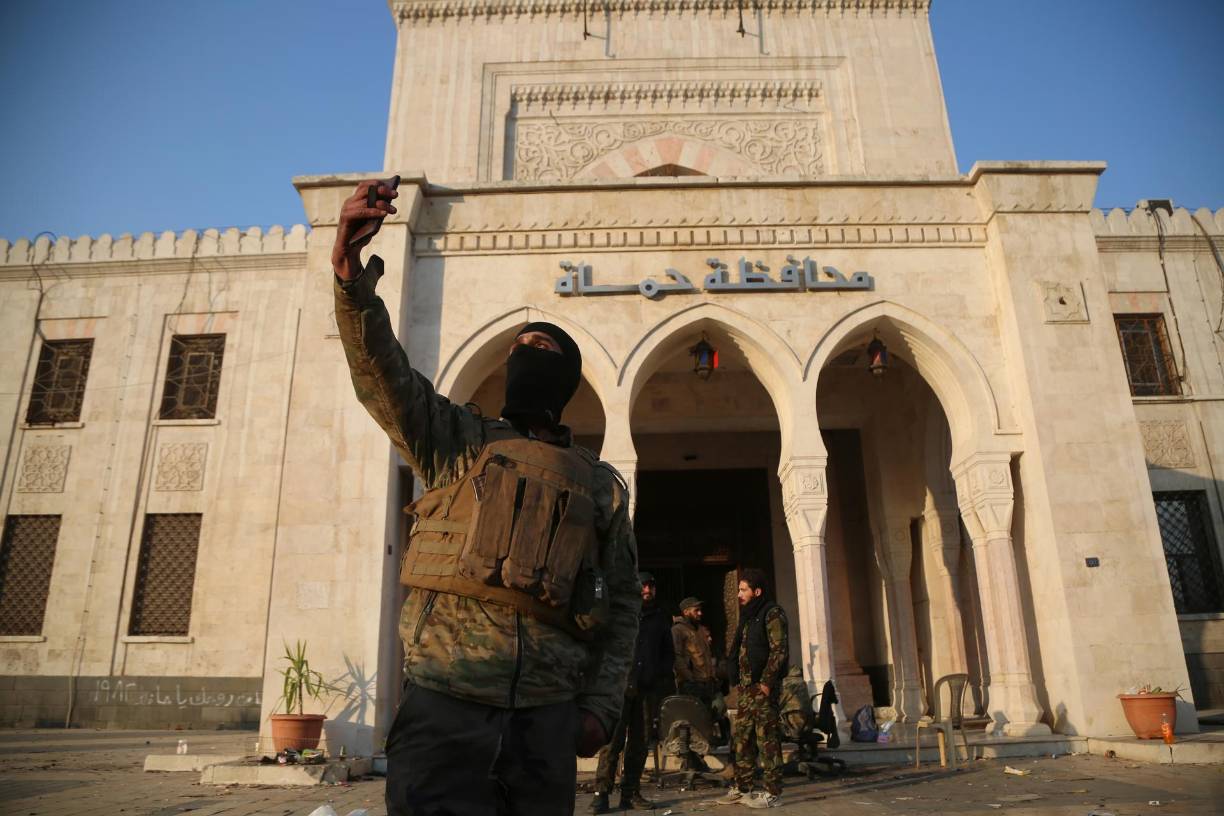 Un rebelde sirio se hace un selfi frente a un edificio del Gobierno después de la toma de la ciudad de Hama, en Siria, el 6 de diciembre. 