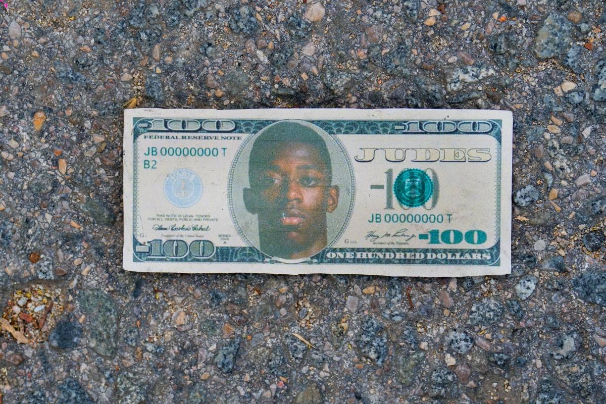 Detalle de un billete con la cara de Ousmane Dembélé en el suelo antes del inicio. 