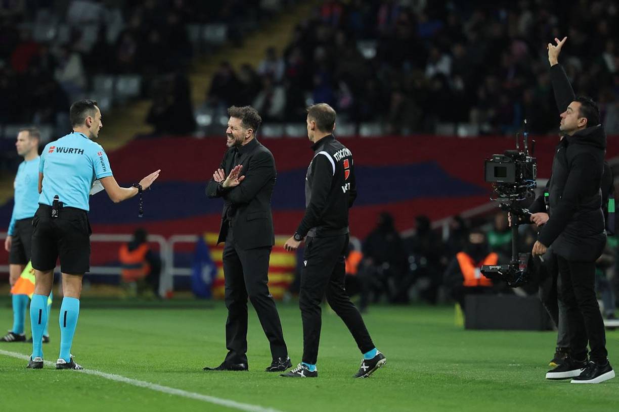 El árbitro José María Sánchez Martínez le pidió calma a Diego Pablo Simeone, mientras Xavi Hernández daba indicaciones a los suyos.