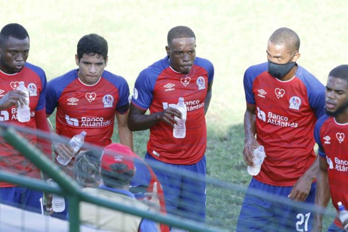 Pedro Troglio dando indicaciones a sus jugadores mientras algunos toman agua, en una pausa del partido.