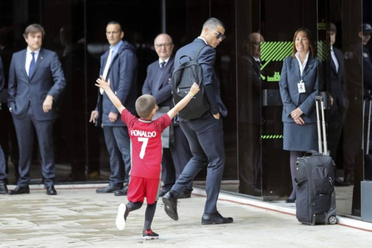 Un pequeño admirador de Cristiano Ronaldo corre hacia el crack portugués con la camiseta de Portugal, cuando llegaban al aeropuerto de Lisboa para viajar a Rusia. Foto EFE
